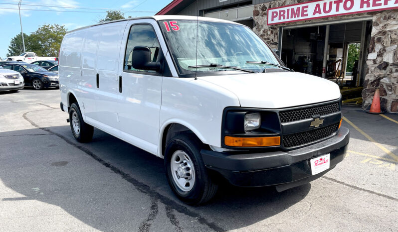 2015 Chevrolet Express G2500 Cargo Van, white with black accents, steel wheels and double side door on passenger side with no windows in the cargo area Exterior view from front passenger corner.